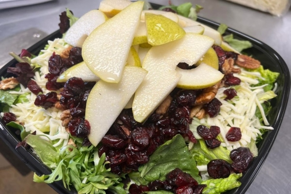 A salad featuring pears, cranberries, cheese and walnuts.