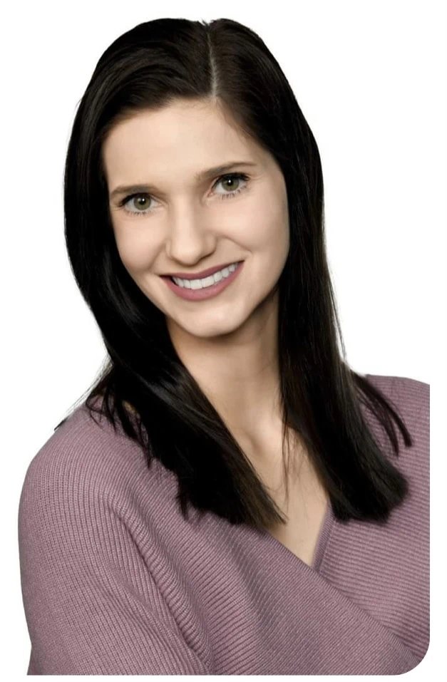 Headshot of Anna Hillyer, owner of What's Cooking Cafe wearing a purple sweater.